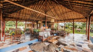 a large pavilion with tables and chairs on a patio at Mama Washindi Lodge in Pakwach East