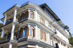 een groot wit gebouw met oranje ramen bij Roamers Inn - Hostel in Pokhara