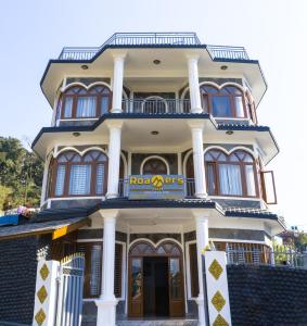 een hoog gebouw met een bord erop bij Roamers Inn - Hostel in Pokhara