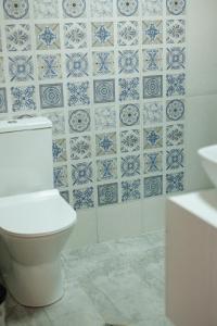 La salle de bains est pourvue de toilettes et de carrelage bleu et blanc. dans l'établissement SMART Via Kazbegi, à Kazbegi