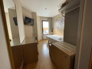 Habitación con dormitorio con cama y espejo. en Nuevo Zenit Calahorra en Calahorra
