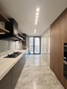 a large kitchen with white counters and a large window at Shanghai Jing'an Art Pavilion-Large 3Bedrooms South-north Direct Sunny House in Shanghai