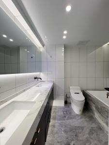 a white bathroom with a tub and a toilet at Shanghai Jing'an Art Pavilion-Large 3Bedrooms South-north Direct Sunny House in Shanghai