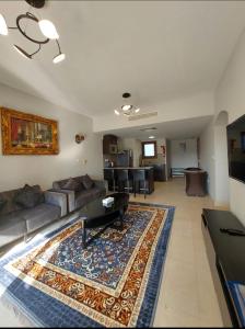 a living room with a couch and a rug at Hawana Marina East 4 in Wādī Khasbar