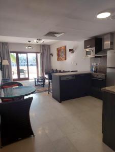 a kitchen and a living room with a table at Hawana Marina East 4 in Wādī Khasbar