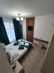 um quarto com uma cama grande e almofadas verdes em ALZ Beach Apartments in Alezzi Beach Resort em Mamaia Nord – Năvodari