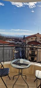 a table and chairs on a balcony with a view at Black and White Apartment in Karlovo