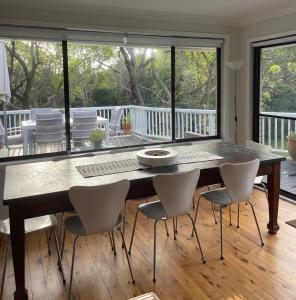 een eetkamer met een tafel en stoelen bij Killcare Beach House in Killcare