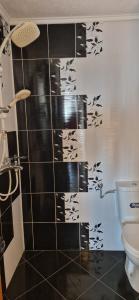 y baño con ducha y azulejos blancos y negros. en Black and White Apartment, en Karlovo