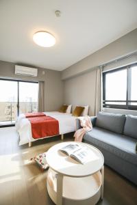 een woonkamer met een bed en een bank bij One-asakusa in Tokyo