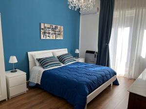 - une chambre bleue avec un lit et un mur bleu dans l'établissement Gioia di Casa - Appartamento, à Paterno