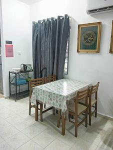 einen Esstisch mit Stühlen, einem Tisch und einem Vorhang in der Unterkunft Homestay HNH Melaka (Corner Lot) in Malakka
