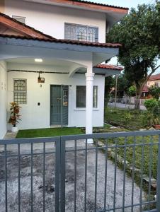 una casa blanca con una valla delante en Homestay HNH Melaka (Corner Lot), en Melaka