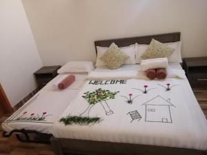 a bed with a white comforter with flowers on it at Sabba Beach Suite , Fodhdhoo - Maldives in Velidhoo