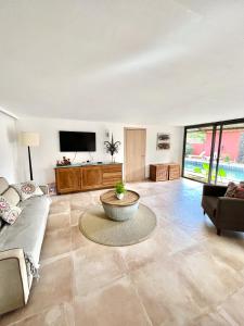 un ampio soggiorno con divano e TV di Residence Laurada - Tropical 2 Bedrooms Villa with Private Pool a Pointe-aux-Piments