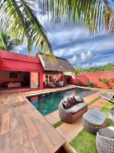 a backyard with a swimming pool and a house at Residence Laurada - Tropical 2 Bedrooms Villa with Private Pool in Pointe aux Piments