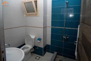 ein Badezimmer mit Toilette, Waschbecken und Spiegel in der Unterkunft Fox Beach Stay in Hurghada + 10 Fotos