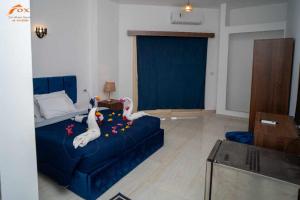 ein Wohnzimmer mit einer blauen Couch mit Schwänen darauf in der Unterkunft Fox Beach Stay in Hurghada
