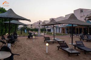 eine Gruppe von Bänken und Sonnenschirmen in einem Innenhof in der Unterkunft Fox Beach Stay in Hurghada