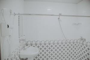 Un baño blanco con inodoro y ducha. en Registan Center Guest House, en Koshbakaly