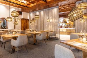 a restaurant with wooden tables and chairs and lights at Hotel Sonnenspitze in Ehrwald