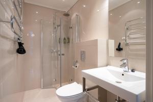 a bathroom with a shower and a toilet and a sink at The Villa Self Check-In Boutique Hotel in Stavanger +79 photos