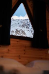 a view of a snow covered mountain through a window at Via Kazbegi in Stepantsminda