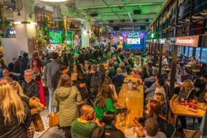 uma multidão de pessoas sentadas à mesa numa sala em Mojo Hotel & Market na Cidade do Cabo