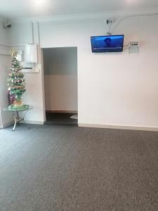 a room with a christmas tree and a tv on a wall at Mikayla hotel in Port Dickson