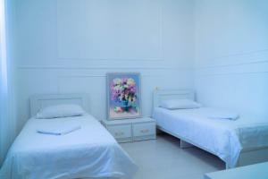 una camera con due letti e un quadro di fiori di Гостиница, Ак-Буура a Bishkek