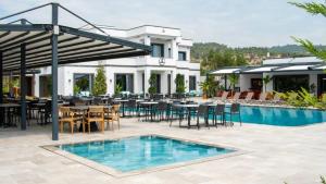 une terrasse avec des tables et des chaises ainsi qu'une piscine dans l'établissement Club Kavala Beach Hotel Assos, à Assos