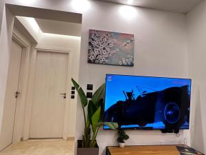 uma sala de estar com uma televisão de ecrã plano na parede em ODYSSEA Top View & Hot Jacuzzi Front Beach em Kremasti