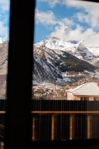a view of a snow covered mountain from a window at Via Kazbegi in Stepantsminda