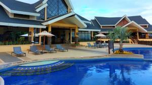 a house with a swimming pool in front of a house at Condo Unit in Alta Vista de Boracay Hotel in Boracay