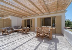 pérgola de madera en un patio con sillas y mesa en Glaros Kouremenos, en Palaikastro