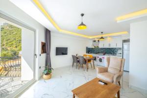 a living room with a table and a kitchen at Yosun Apart in Kaş