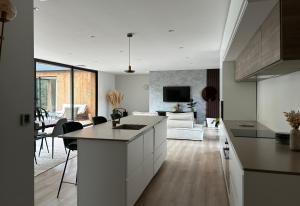 a kitchen and a living room with a couch at Villa au coeur de la forêt in Mano