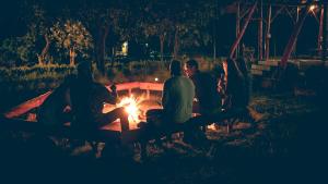 Eine Gruppe von Menschen, die nachts am Lagerfeuer sitzen in der Unterkunft Mama Washindi Lodge in Pakwach East
