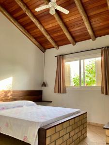 a bedroom with a bed and a ceiling fan at Pousada dos Sambaquis in Jaguaruna