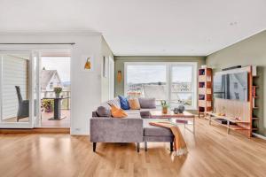 een woonkamer met een bank en een tafel bij Moderne sentralt hjem in Tromsø