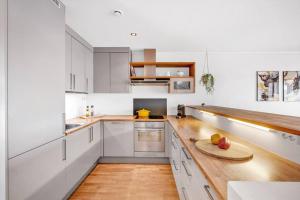 a kitchen with white cabinets and a wooden counter top at Moderne sentralt hjem in Tromsø