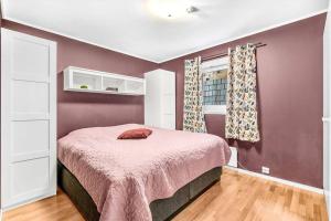 sypialnia z łóżkiem z fioletowymi ścianami i oknem w obiekcie Moderne sentralt hjem w mieście Tromsø