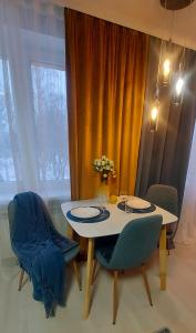 een eettafel met 2 stoelen en een vaas met bloemen bij The Best Choice Narva Center in Narva