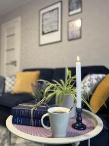 a candle and a cup of coffee and books on a table at The Best Choice Narva Center in Narva