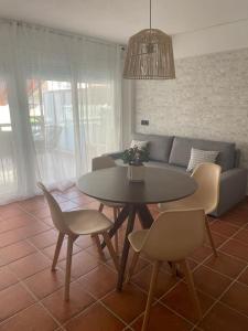 Una sala de estar con una mesa y sillas y un sofá. en Apartamento Ridaura, en Platja d'Aro
