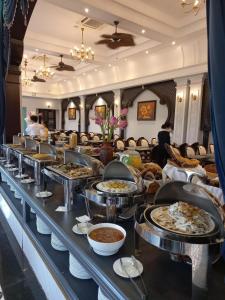 uma linha de buffet com muitos pratos de comida em Vườn Vua Phú Thọ - Sen villas Resort Vườn Vua Thanh Liên 41 Wyndham em Ðồng Phú