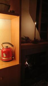 a red toaster sitting on a shelf next to a candle at Campo Felice Apartment in Collimento