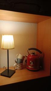 a table with a tea pot and a lamp on it at Campo Felice Apartment in Collimento