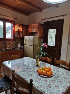 a kitchen with a table with a bowl of oranges on it at LEMON TREE GARDEN near Mirtos beach in Bekatoráta