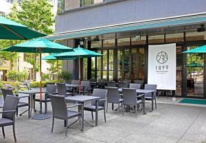 een patio met tafels, stoelen en parasols bij Hotel Ryumeikan Ochanomizu Honten in Tokyo
